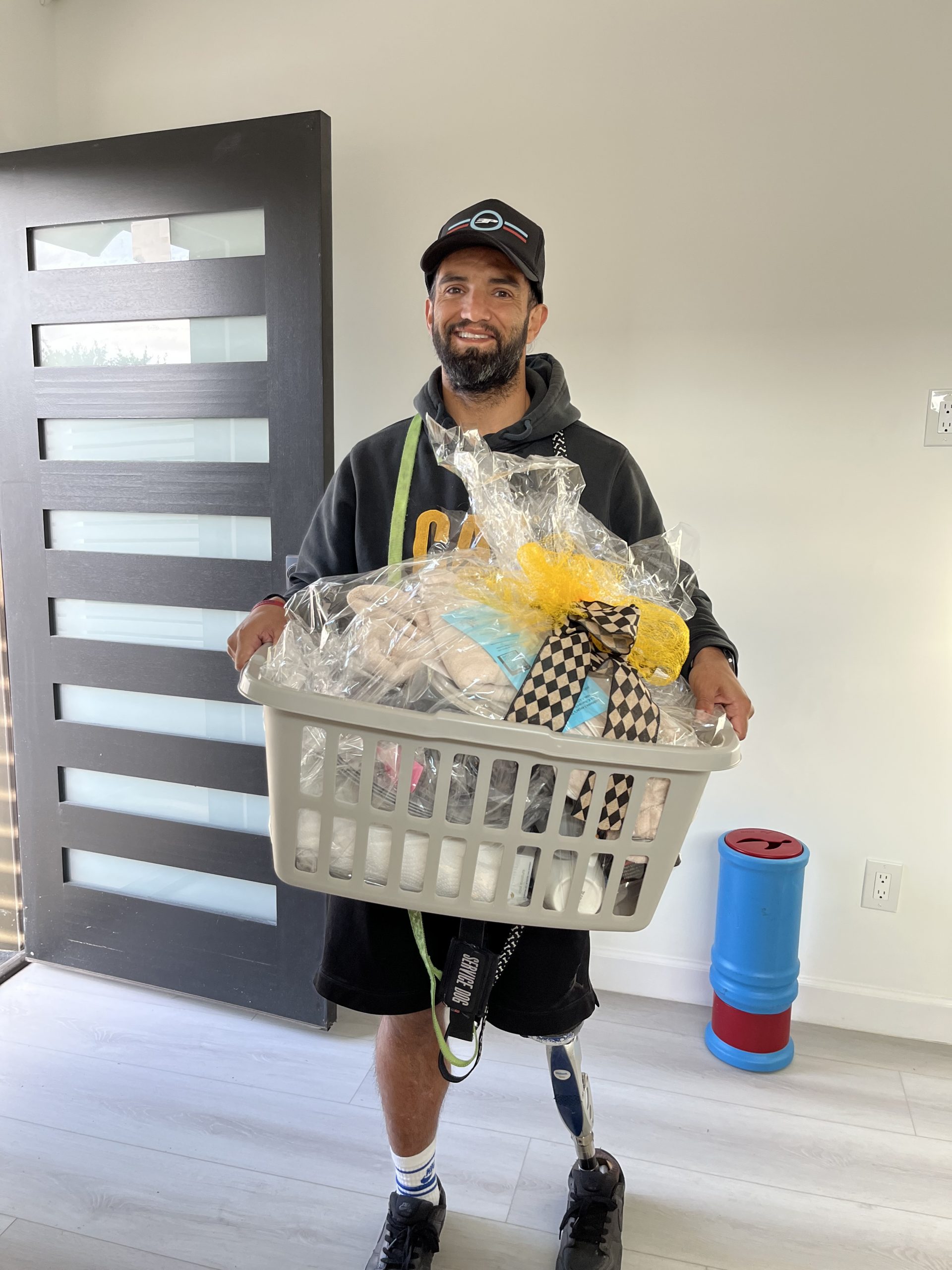 Photo of client in new home and holding a welcome home basket.